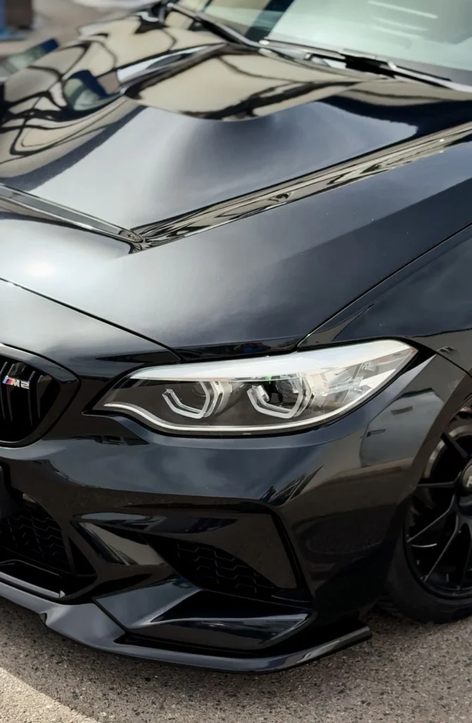 Schwarzer PKW in Nahaufnahme während der Autowäsche